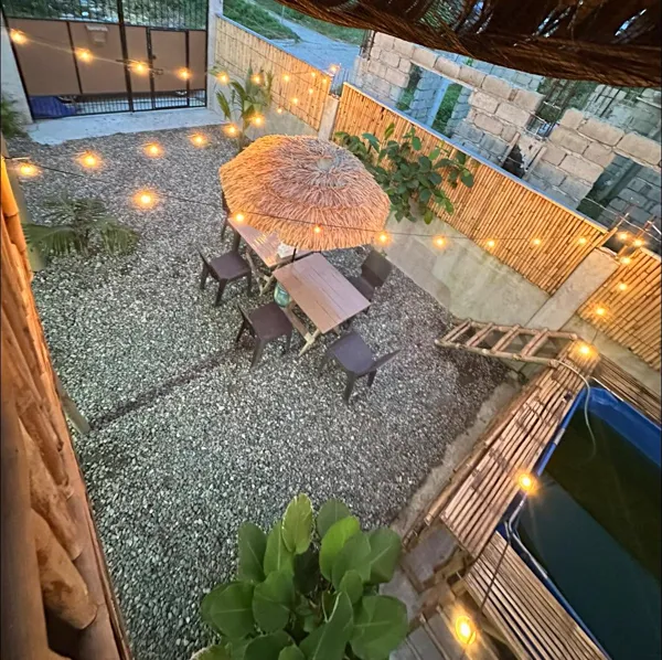 The courtyard, umbrella table, and pool edge seen from above.